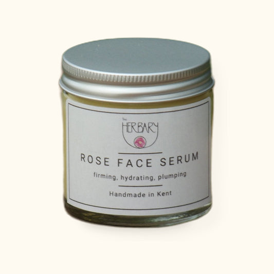 Rose Face Serum on cream background with shadow