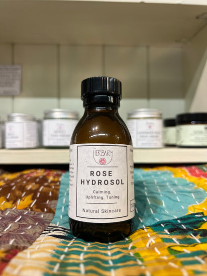 Bottle of Rose Hydrosol with a label on a colorful fabric background