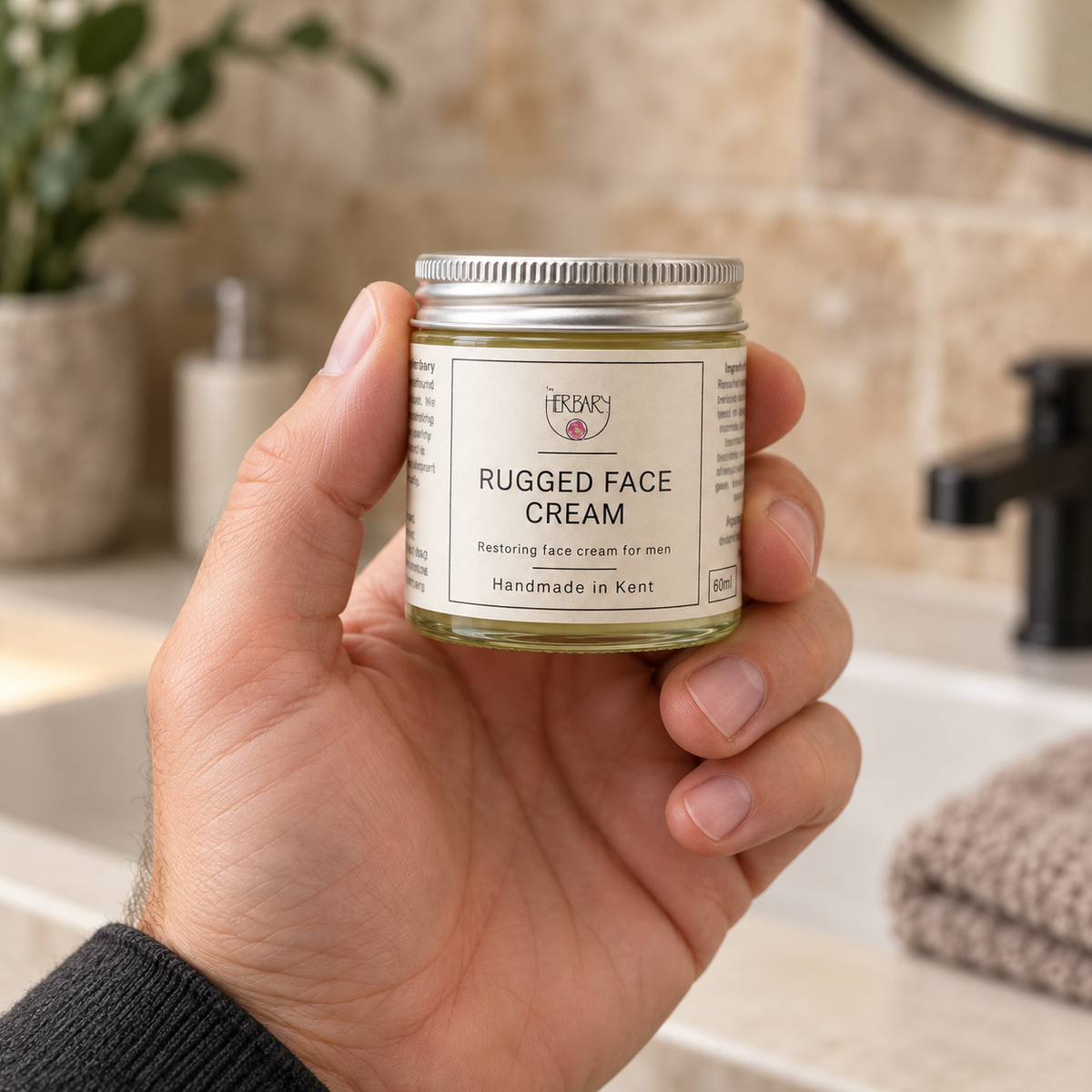 Rugged Face Cream 60ml jar held in one hand — The Herbary
